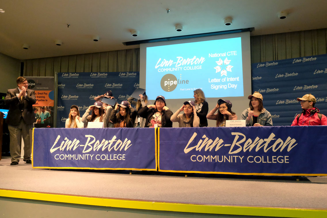 Students signing letters of acceptance to LBCC technical training programs.