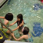 Three girls entering swimming pool