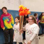 Students carry Olympic Torch.