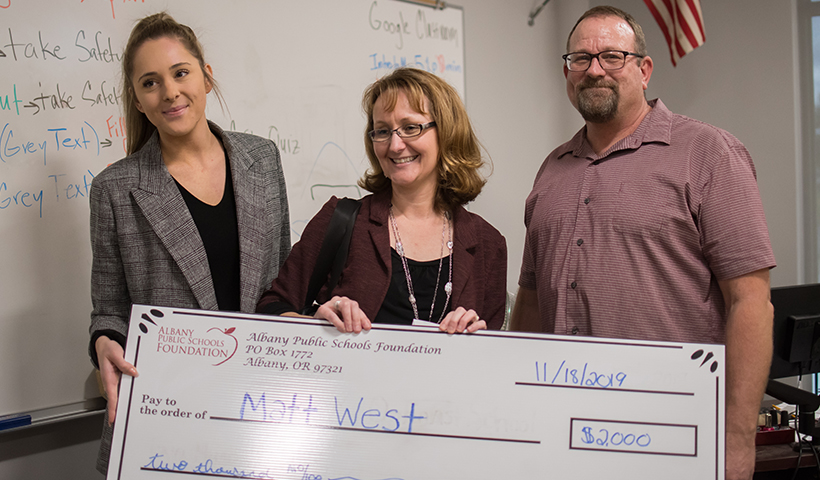 APSF Executive Director Aimee Addison presenting a grant check to teacher Matthew West