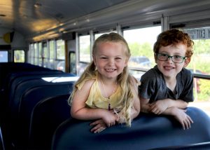Two children sitting on a school bus. 