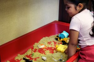 Little girl playing in sand box